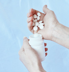 White pills fall in hand