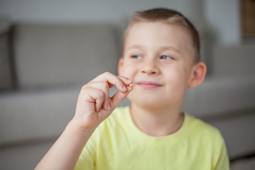 The child dropped the first milk tooth. Happy little boy and milk tooth.