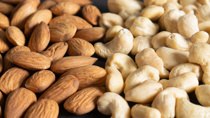Organic peeled almond nuts and cashew seeds as background, top view. Healthy snack. Different healthy nuts