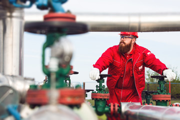 Engineer maintaining oil pipeline with all protective gear.