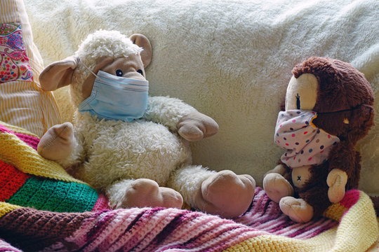 Two childrens plush stuffed animal toys earing a face mask during the COVID-19 pandemic