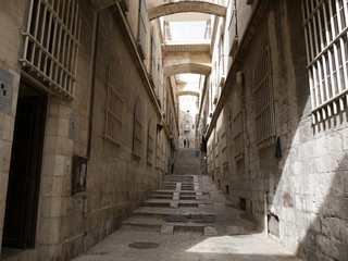 stone alley in old Jerusalem Israel with bars on windows with shadows