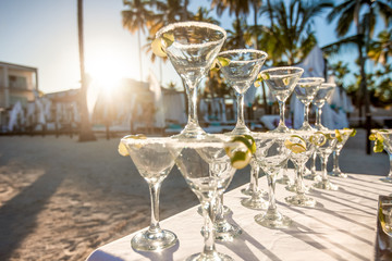 Margarita cocktails, lemonade and champagne sparkling wine glasses on beach outdoor catering event 