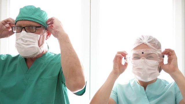 Doctor and nurse put on medical masks. Preparing to receive patients. COVID-19.