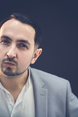 Funny handsom businessman in trendy taxedo looking at the camera with playful, comical face expression.