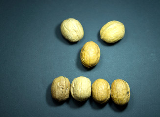 Emotion anger, irritability. Smile. Dried fruits, walnuts. Black background.
