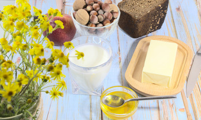 Natural ecological products on the table. Honey with milk in a glass for a healthy breakfast. A sandwich of rye bread and butter.