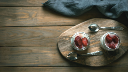 Two jars of yogurt on a wooden stand