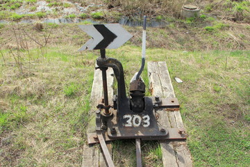 Railway arrow in black with a lever and pointer in Russia. The device for the transfer of rails at intersections for trains. Technical element of the railway industry.