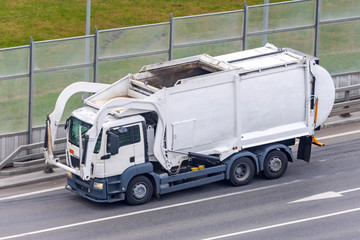 Garbage truck for the transportation of waste goes on city road. © aapsky