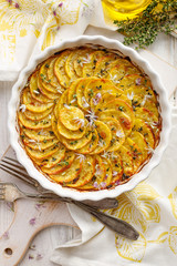 Scalloped potatoes, potato casserole with the addition of herbs and edible chives flowers, top view