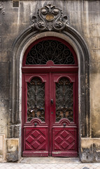 Old red wooden vintage archway doors in old town Bordeaux, France