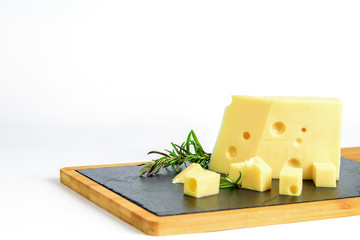 Fresh sliced emmental cheese with rosemary on the kitchen cutting board. Healthy food with calcium.