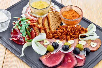 A wooden table topped with plates of meat plate