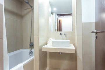 Fototapeta na wymiar Modern bathroom with bathtub, mirror and washbasin. European hotel design.