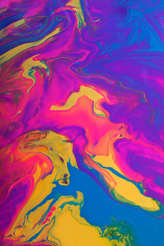 Colorful marble background.Mixed polishes-yellow,pink,blue and purple.Colorful marble background.Beautiful stains of liquid nail polish,fluid art technique.Pour painting technique.Vertical banner.