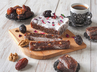 Homemade marmalade sweets with date fruits and nuts, eastern candies on a white wooden surface