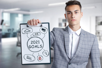 Business, Technology, Internet and network concept. Young businessman working on a virtual screen of the future and sees the inscription: 2021 goals