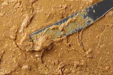 Peanut butter and knife, background and texture, top view