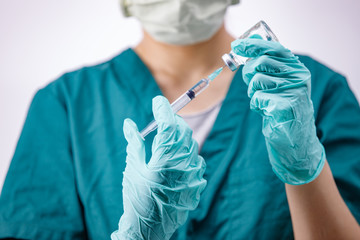 Female doctor with medical scrub holding syringe and vaccine. Healthcare And Medical concept on white background.