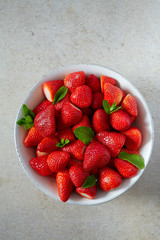 strawberries with mint leafs on granite surface