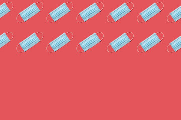 COVID-19 disposable surgical face mask on red background. Protection against coronavirus. Healthcare and medical concept. Seamless medical pattern with copyspace