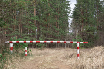 Obraz na płótnie Canvas The barrier is red and white. Ban on visiting the forest. Fire hazard in the forest.