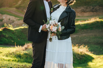 The bride hugs the groom. Groom backs into the frame. The concept of a happy wedding.