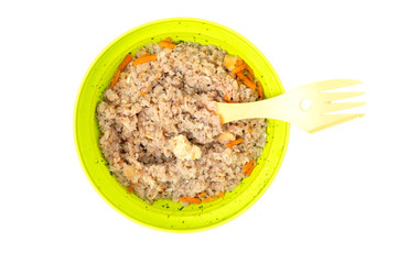 Buckwheat porridge in a bowl with a spoon. Porridge in a tourist bowl. Tourist food.