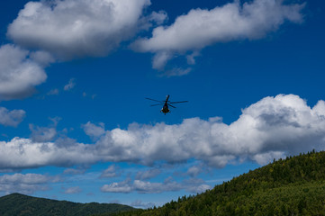 Fototapeta na wymiar takeoff and landing helicopter in the mountains
