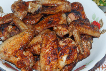  full plate with chicken wings cooked on fire, close-up  