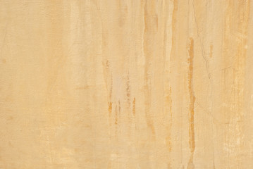 Orange concrete wall with cracks and scratches. Texture of scratched, old and worn wall close up.