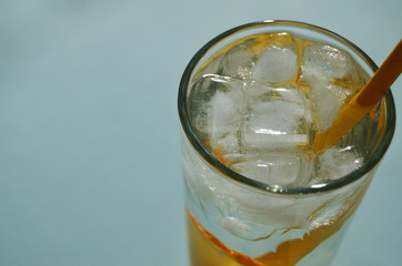 lemon water with ice in a glass glass with a yellow tube close-up view from above with a copy space