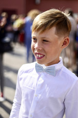  A boy in a white shirt and with a bow tie. Beginning of the school year. Close-up.