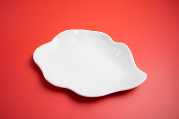 A white plate on a red background