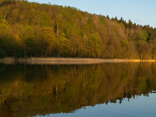 Hancza Lake, the deepest lake of the Poland. Sunny day, late afternoon, sky reflecting in the water. Suwalski landscape park, Podlaskie, Poland
