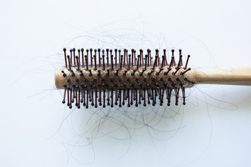 round comb with lots of hair on a white background, close-up hair loss, isolate