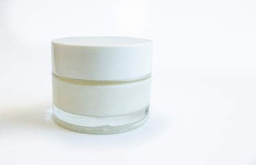 cosmetic glass jar with cream on a white, brown background and with an open lid, copy pace isolate, closeup
