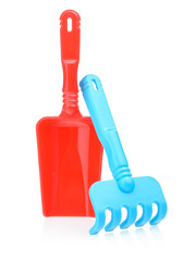 Toy rake and shovel made of plastic on a white background. Children's shovel and rake for playing...