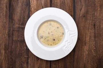 Cream soup with mushrooms and on wooden table. A plate of  Mushroom Cream-soup. Top view. 