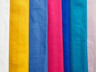 Fototapeta premium Multicolored cotton samples in vertical position. Woven texture and background.