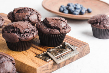 Homemade chocolate muffins on rustic wooden board