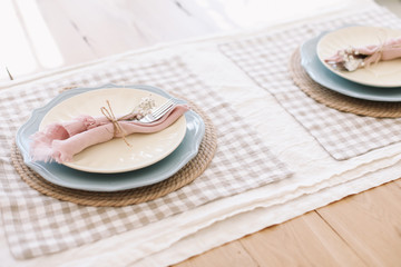 Elegant table setting. Table set for fine dining with metal fork and linen napkins on a plate. Home decor rustic table setting