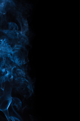 The movement of the smoke on a black background .