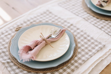 Elegant table setting. Table set for fine dining with metal fork and linen napkins on a plate. Home decor rustic table setting