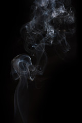 The movement of the smoke on a black background .