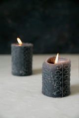 Fototapeta na wymiar Two burning black candles on a marble background