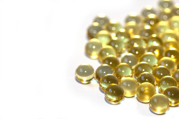 Yellow fish oil in capsules on a white background. Omega3 vitamins close-up. Capsules fish oil macro. Vitamins for health.