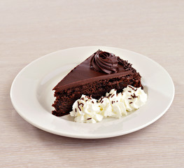 Chocolate cake with cream on white plate