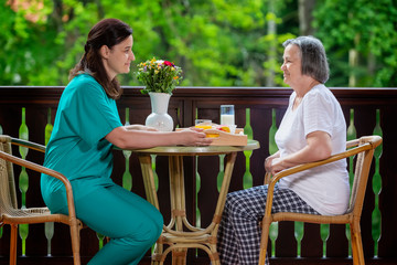 Health care worker serving a meal to an elderly patient